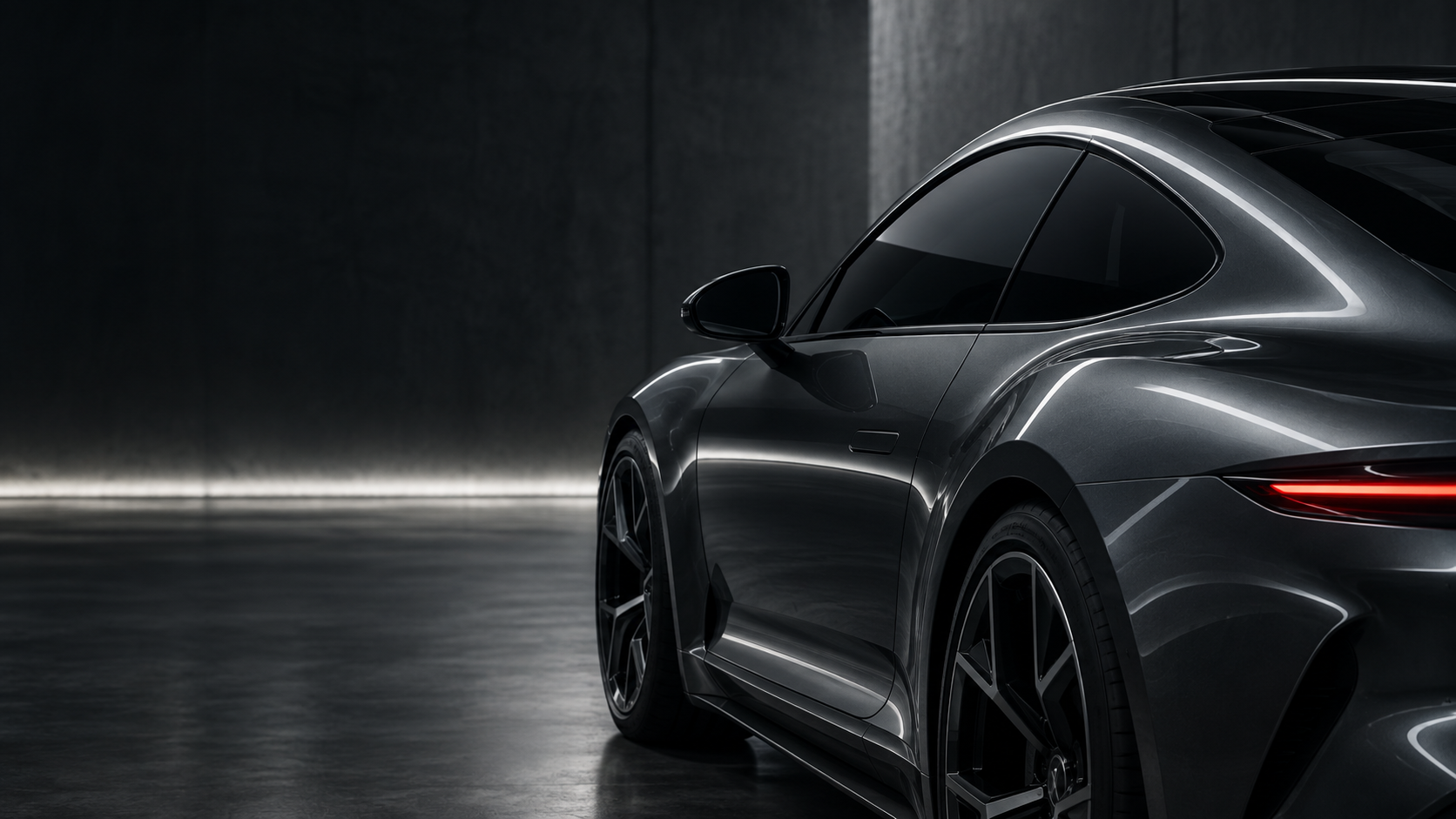 Graphite sports coupe with dark window glass in a concrete studio